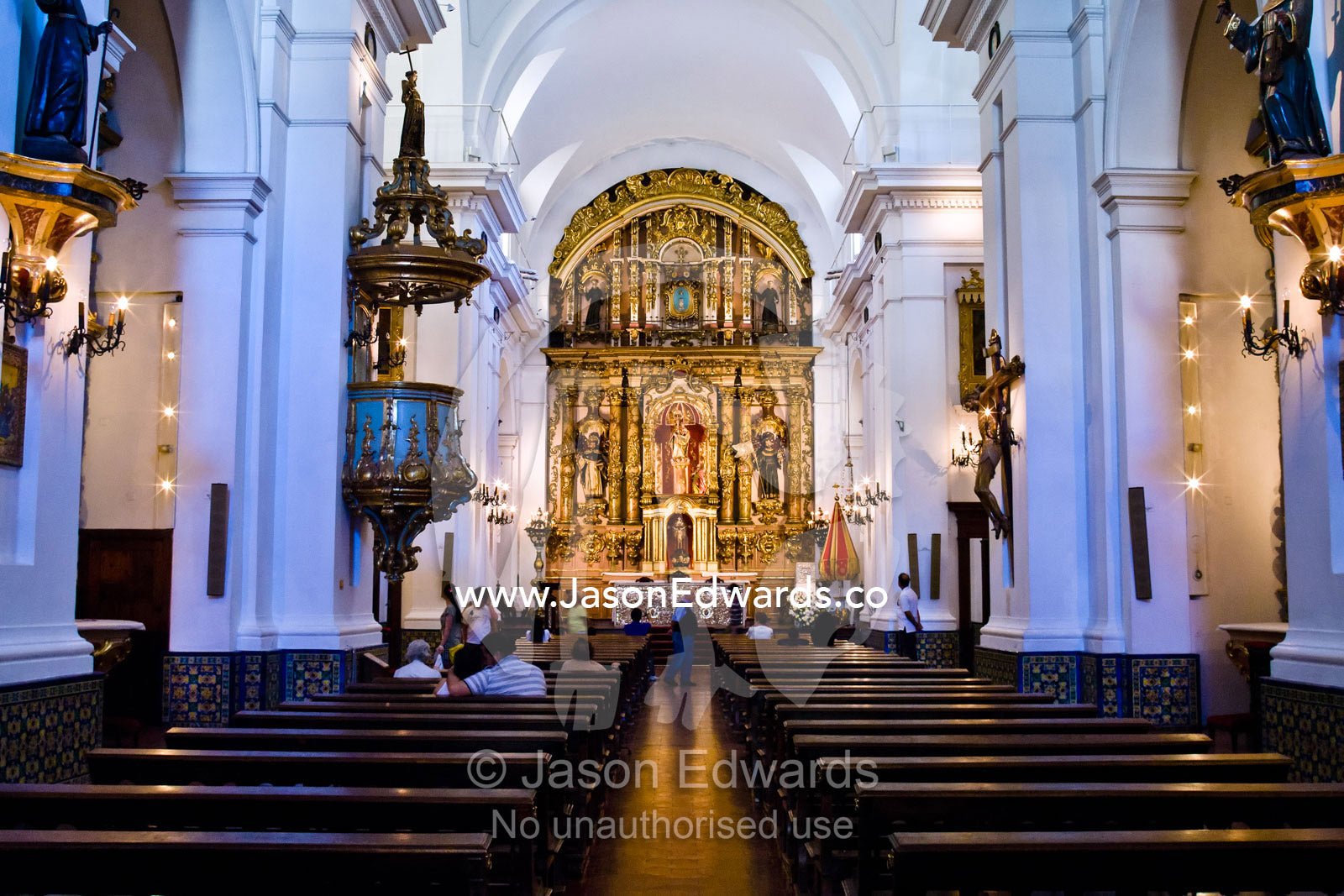 The nave, pews, aisle, and clerestory windows of an ornate church. Our Lady of Pilar Basilica, Recoleta, Buenos Aires, Argentina.
