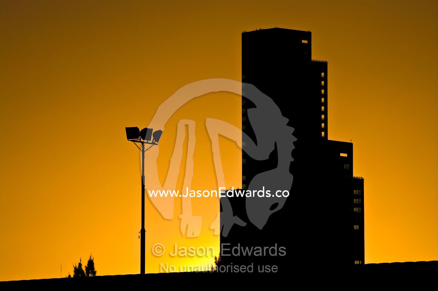 A large monolithic building and floodlights silhouetted at sunset. near Estacion Retiro, Retiro Railway Station, Buenos Aires, Argentina.