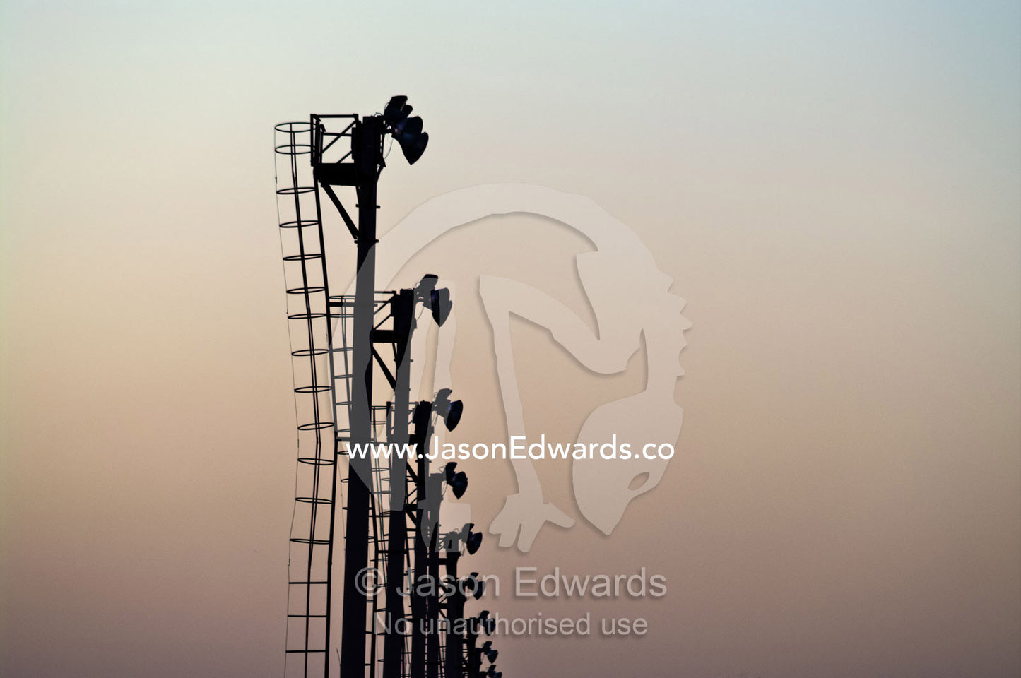 A large row of floodlights at a horse racing track at sunset. Buenos Aires, Argentina.