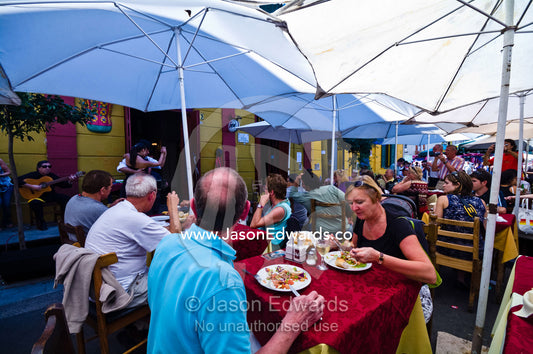 Tourists dine at a restaurant whilst watching Tango dancers perform. La Boca, Buenos Aires, Argentina.