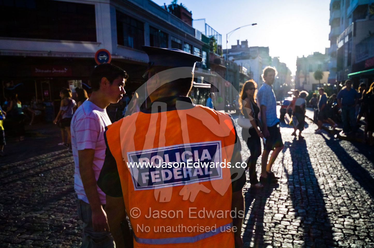 A police officer monitors crowds at a weekend street market. Calle Defensa, San Telmo, Buenos Aires, Argentina.