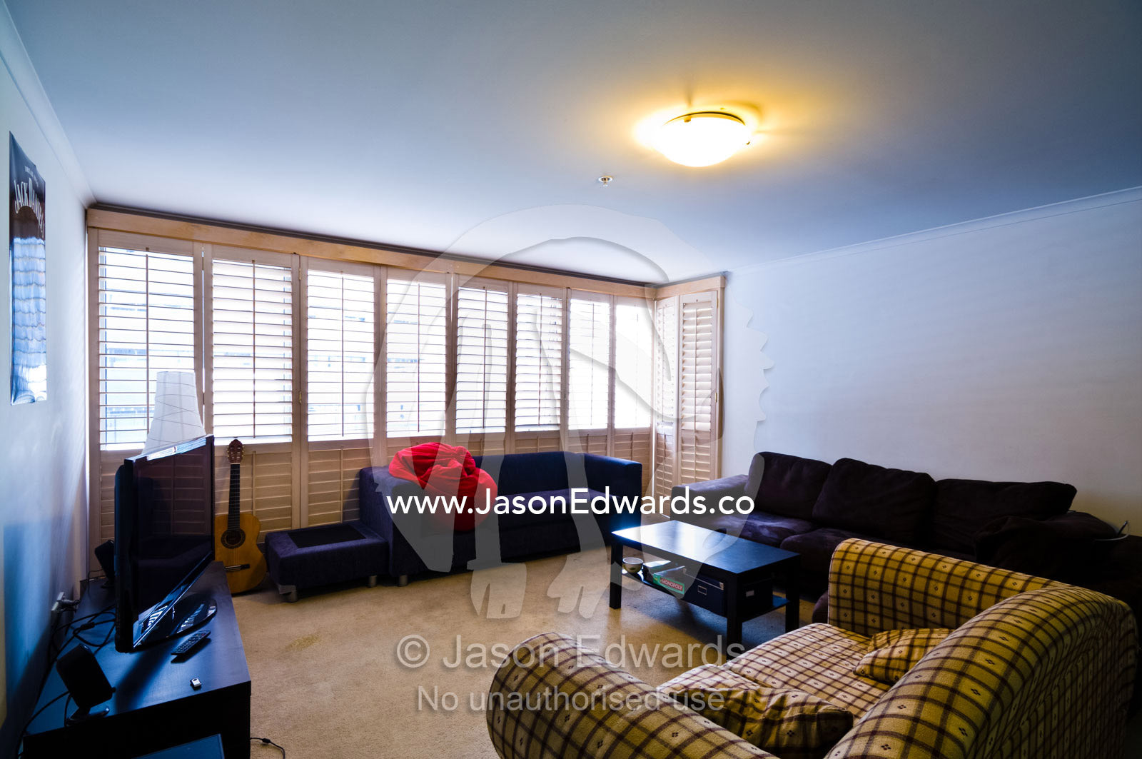 Mismatched sofa furniture in the living room of a students apartment. St Kilda Road, Melbourne, Victoria, Australia.