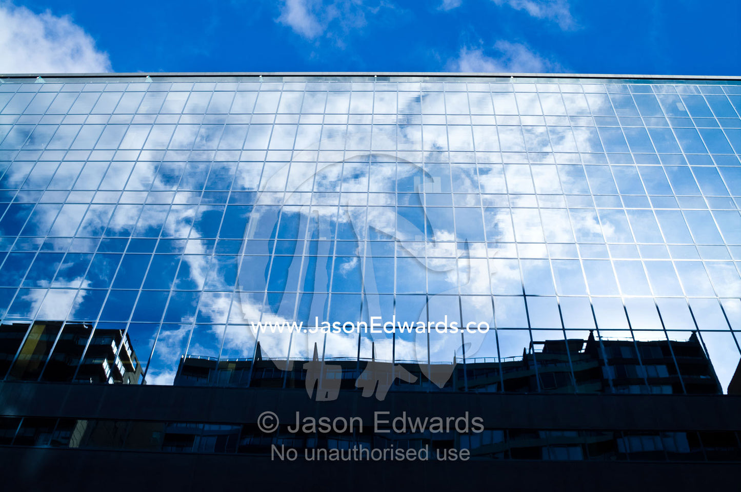 Blue sky and clouds reflected in the windows of an office complex. St Kilda Road, Melbourne, Victoria, Australia.