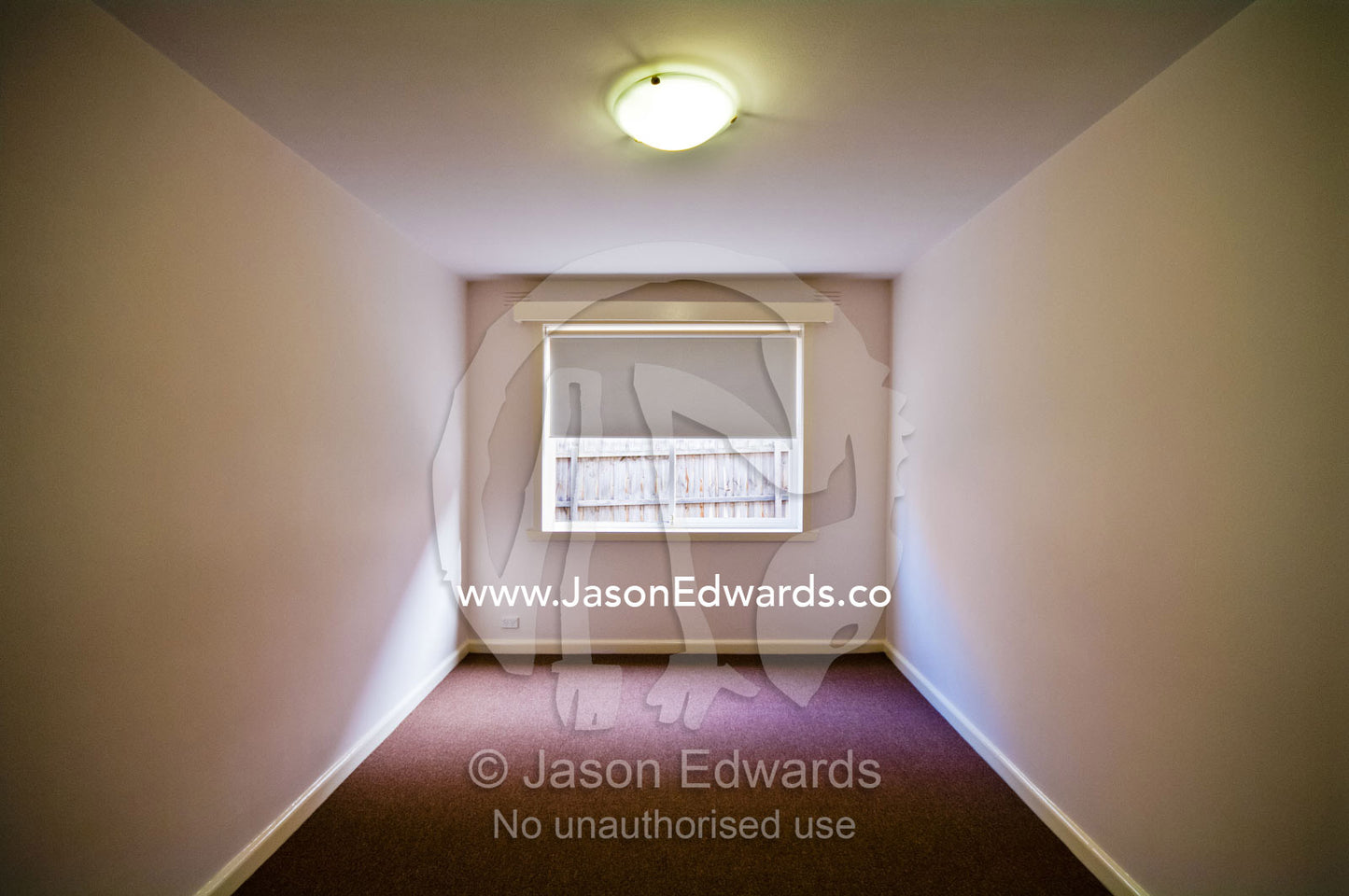 A carpeted plain and empty bedroom in an uninhabited apartment. Hawthorn East, Melbourne, Victoria, Australia.