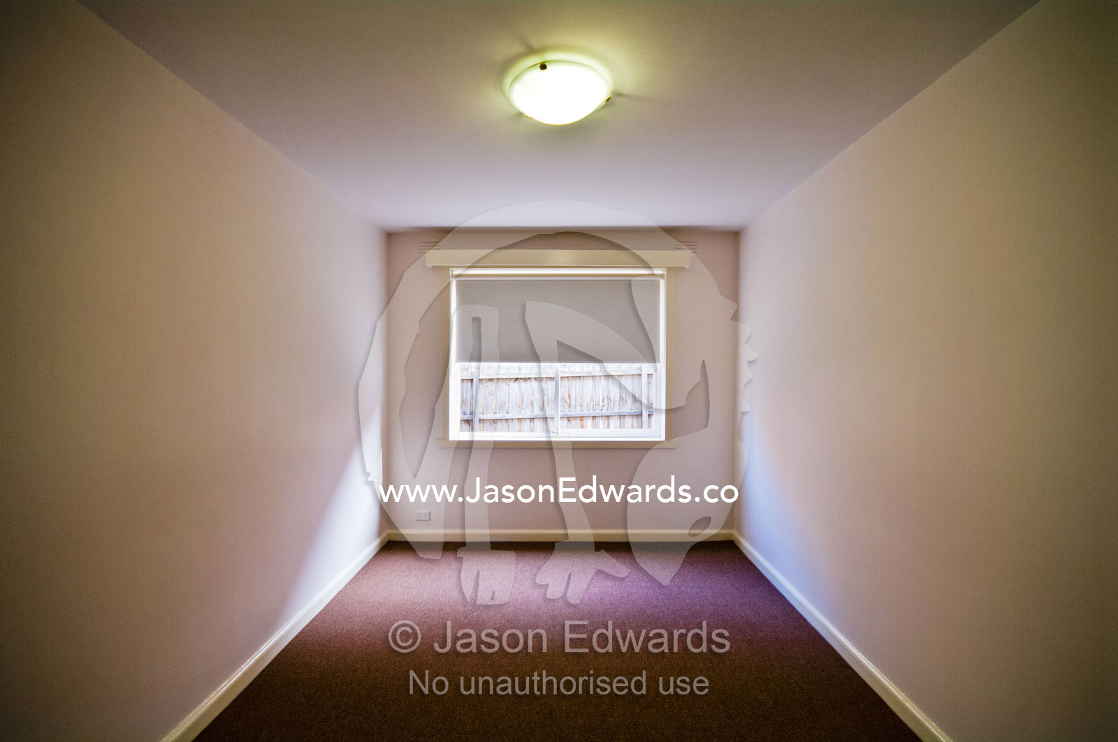 A carpeted plain and empty bedroom in an uninhabited apartment. Hawthorn East, Melbourne, Victoria, Australia.