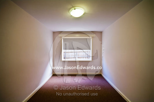 A carpeted plain and empty bedroom in an uninhabited apartment. Hawthorn East, Melbourne, Victoria, Australia.