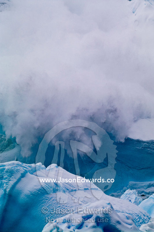 An avalanche of snow and ice crashes down a mountainside in Antarctica Crystal Sound, Hansen Island, Hanusse Bay, Antarctic Peninsula, Antarctic Circle, Antarctica.