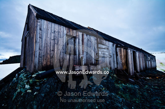 Weathered ruins of an abandoned Antarctic scientific research station. Station W, Detaille Island, Antarctic Peninsula, Antarctic Circle, Antarctica.
