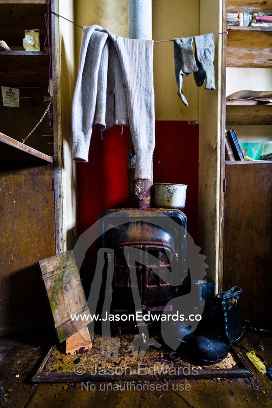 Coal stove, leather boots and thermal underwear at a research station. Station W, Detaille Island, Antarctic Peninsula, Antarctic Circle, Antarctica.
