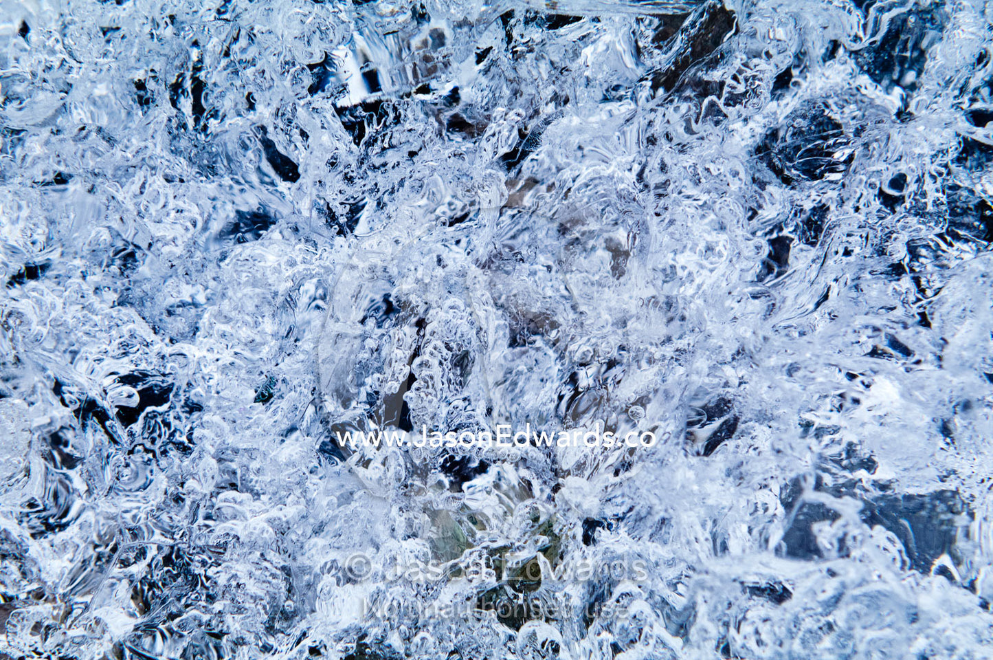 Mosaic patterns of air bubbles trapped in a block of transparent ice. Prospect Point, Crystal Sound, Antarctic Peninsula, Antarctic Circle, Antarctica.