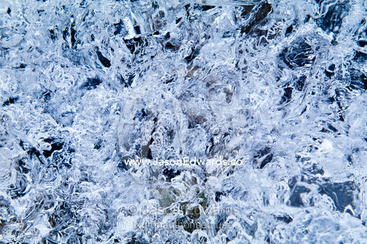 Mosaic patterns of air bubbles trapped in a block of transparent ice. Prospect Point, Crystal Sound, Antarctic Peninsula, Antarctic Circle, Antarctica.