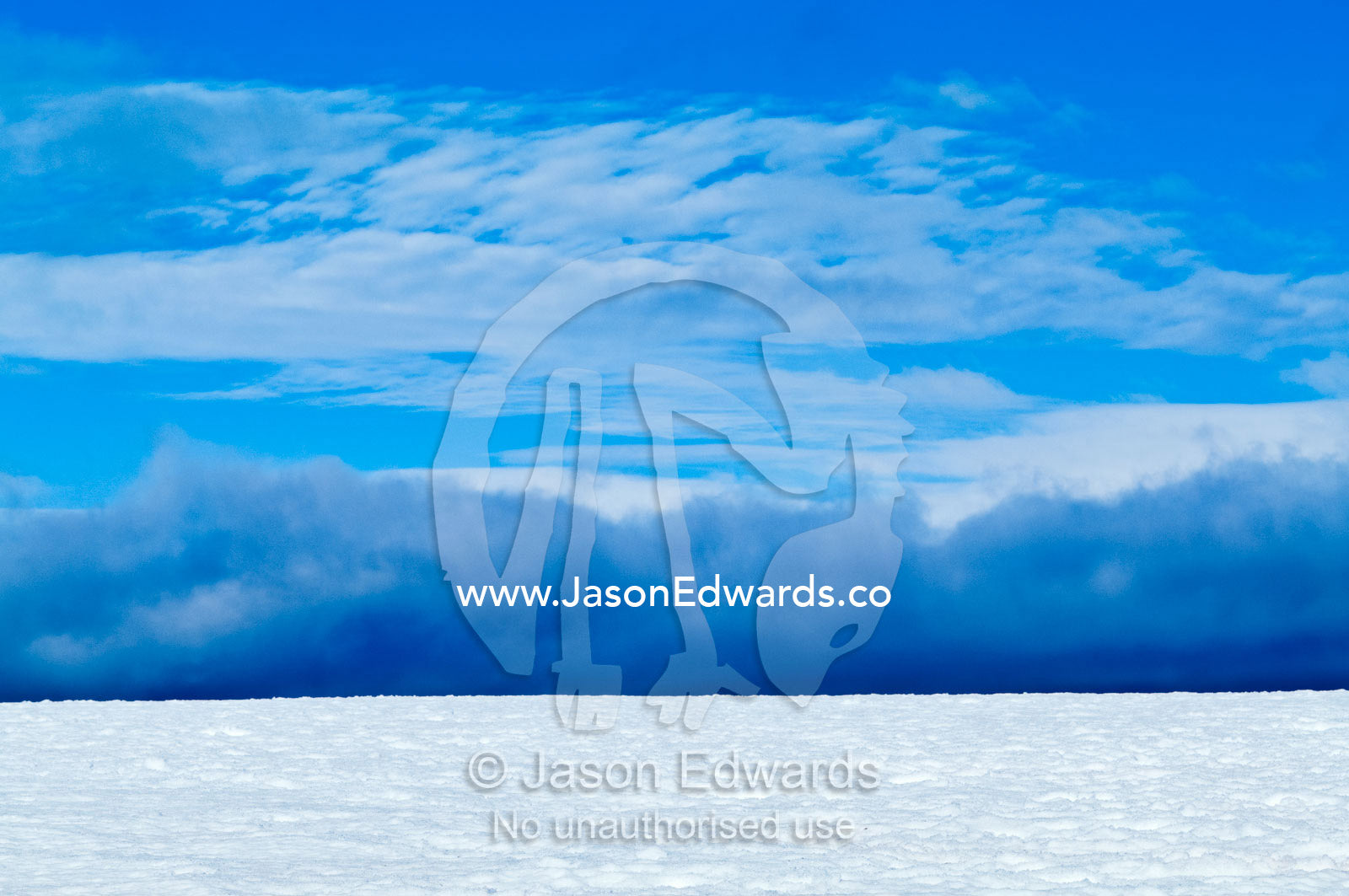 Dark storm clouds rise over the horizon and a snowy plain. Prospect Point, Crystal Sound, Antarctic Peninsula, Antarctic Circle, Antarctica.