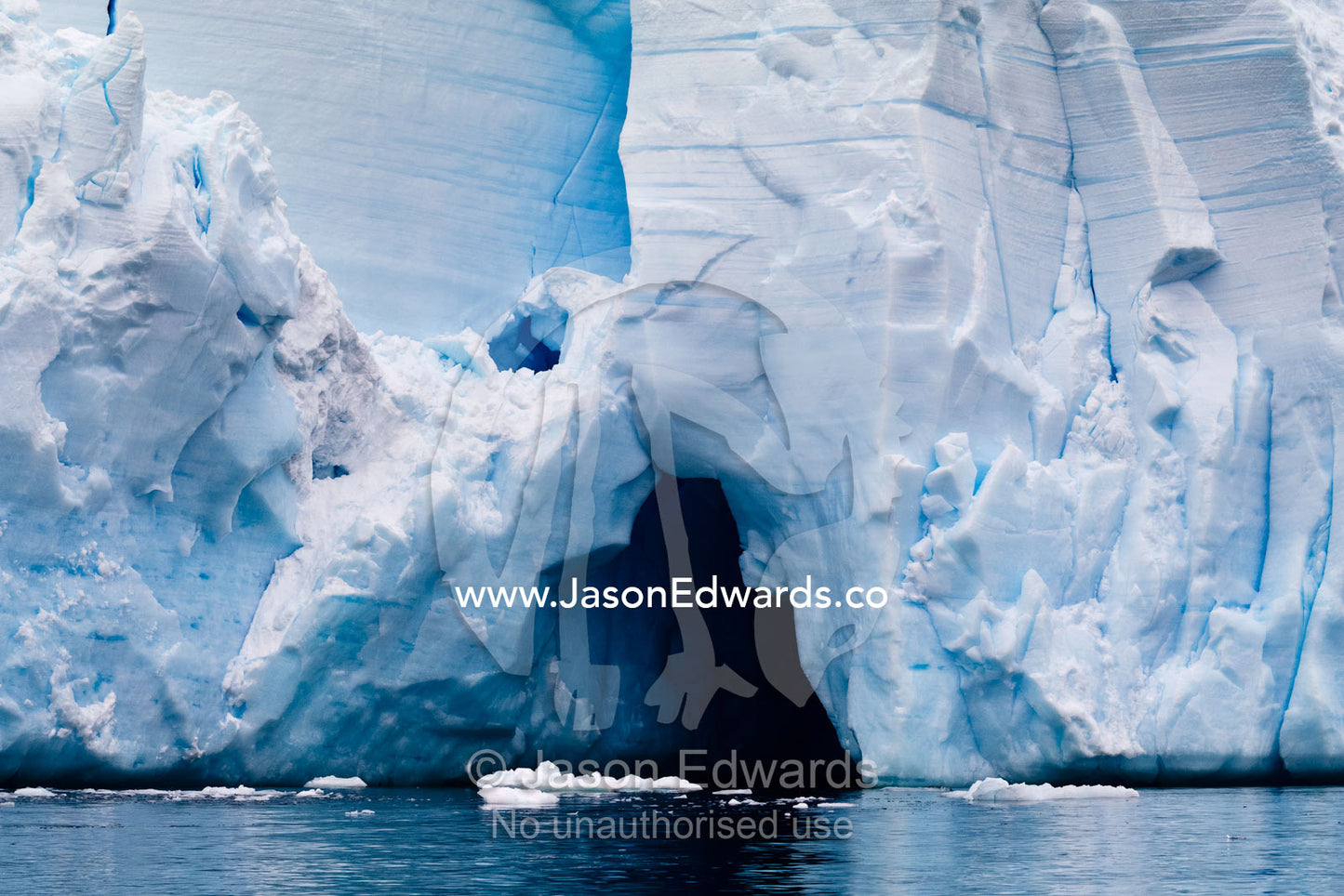An ice cave at the base of a glacier eroded by freshwater melting. Fish Islands, Flouder Island, The Minnows, Crystal Sound, Antarctic Peninsula, Antarctic Circle, Antarctica.