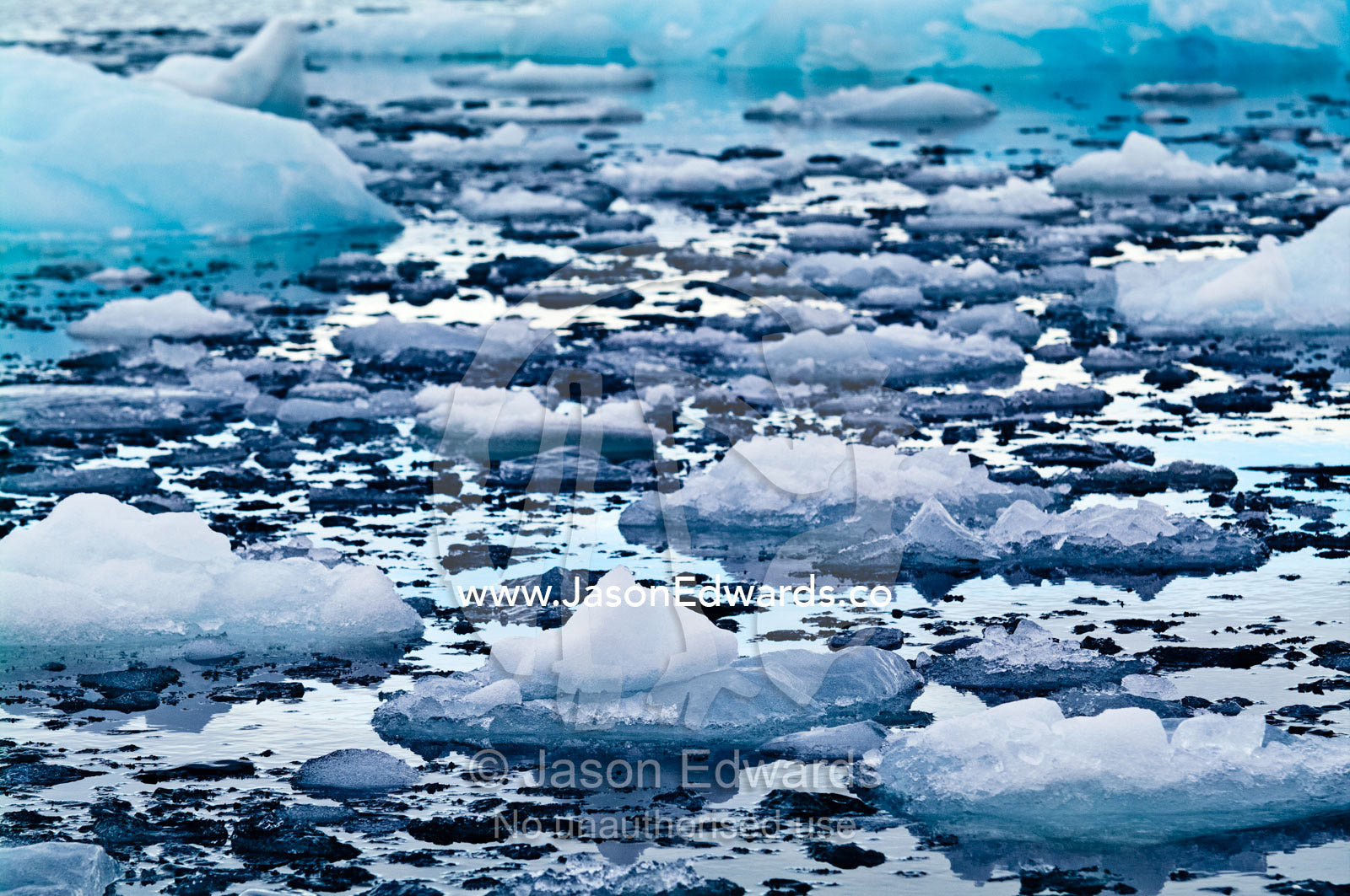 Crushed ice and fractured icebergs on the surface of a calm sea. Fish Islands, Flouder Island, The Minnows, Crystal Sound, Antarctic Peninsula, Antarctic Circle, Antarctica.