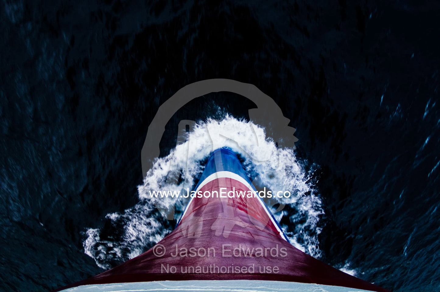 The steel bow of an ice strengthened ecotourism ship ploughs the sea. Lemaire Channel, Antarctic Peninsula, Antarctica.