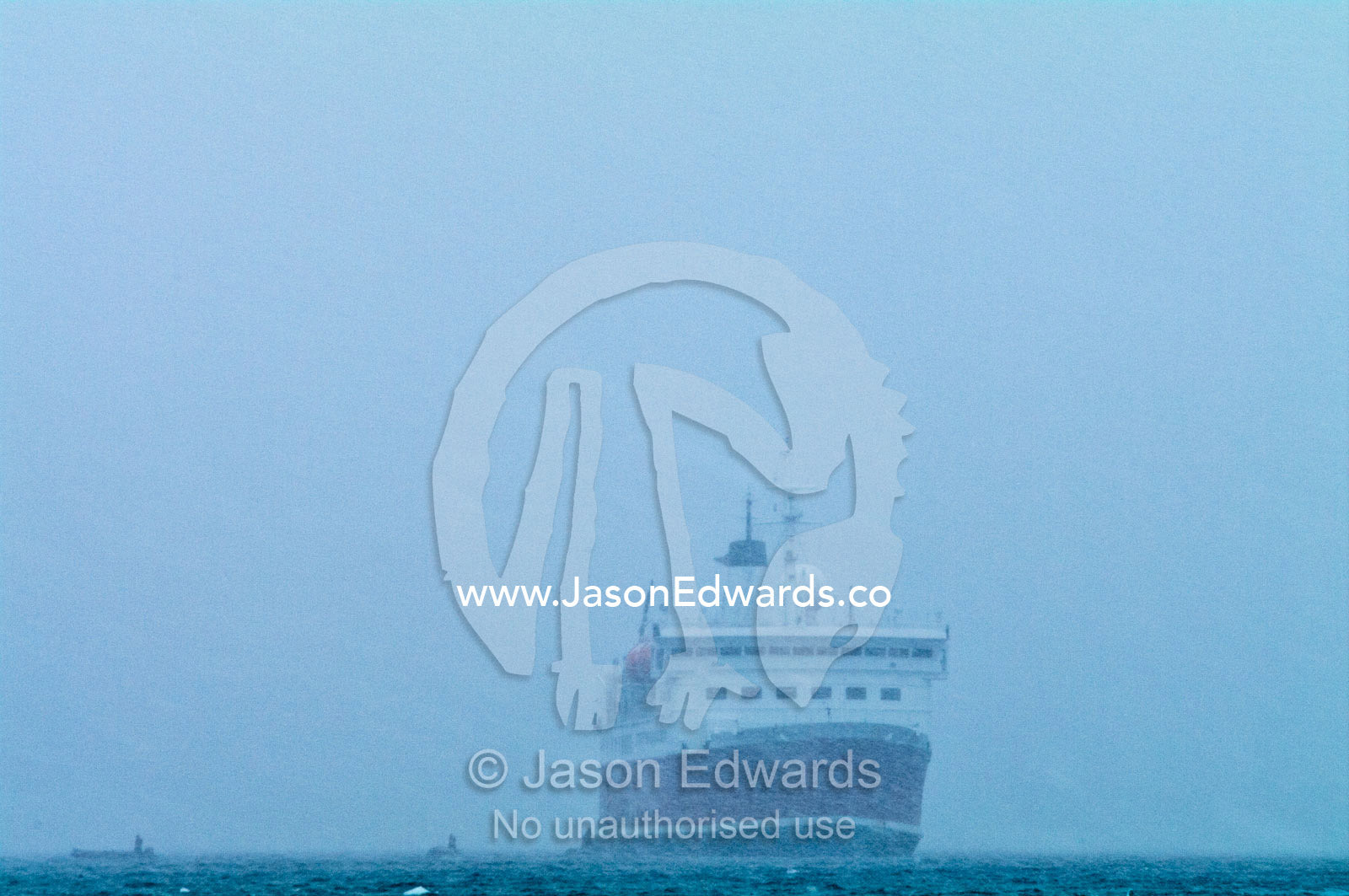 Small inflatable zodiac boats and an ecotourism ship in a blizzard. Danco Island, Antarctic Peninsula, Antarctica.