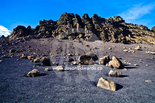 Boulders emerge from a deserted black volcanic sand beach. Neptune's Window, Whalers Bay, Port Foster, Deception Island, South Shetland Islands, Antarctic Peninsula, Antarctica.