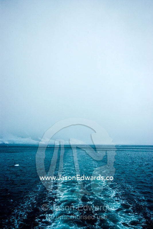 The wake of an ecotourism ship as it passes between an ice passage. Gerlache Strait, Graham Land, Antarctic Peninsula, Antarctica.