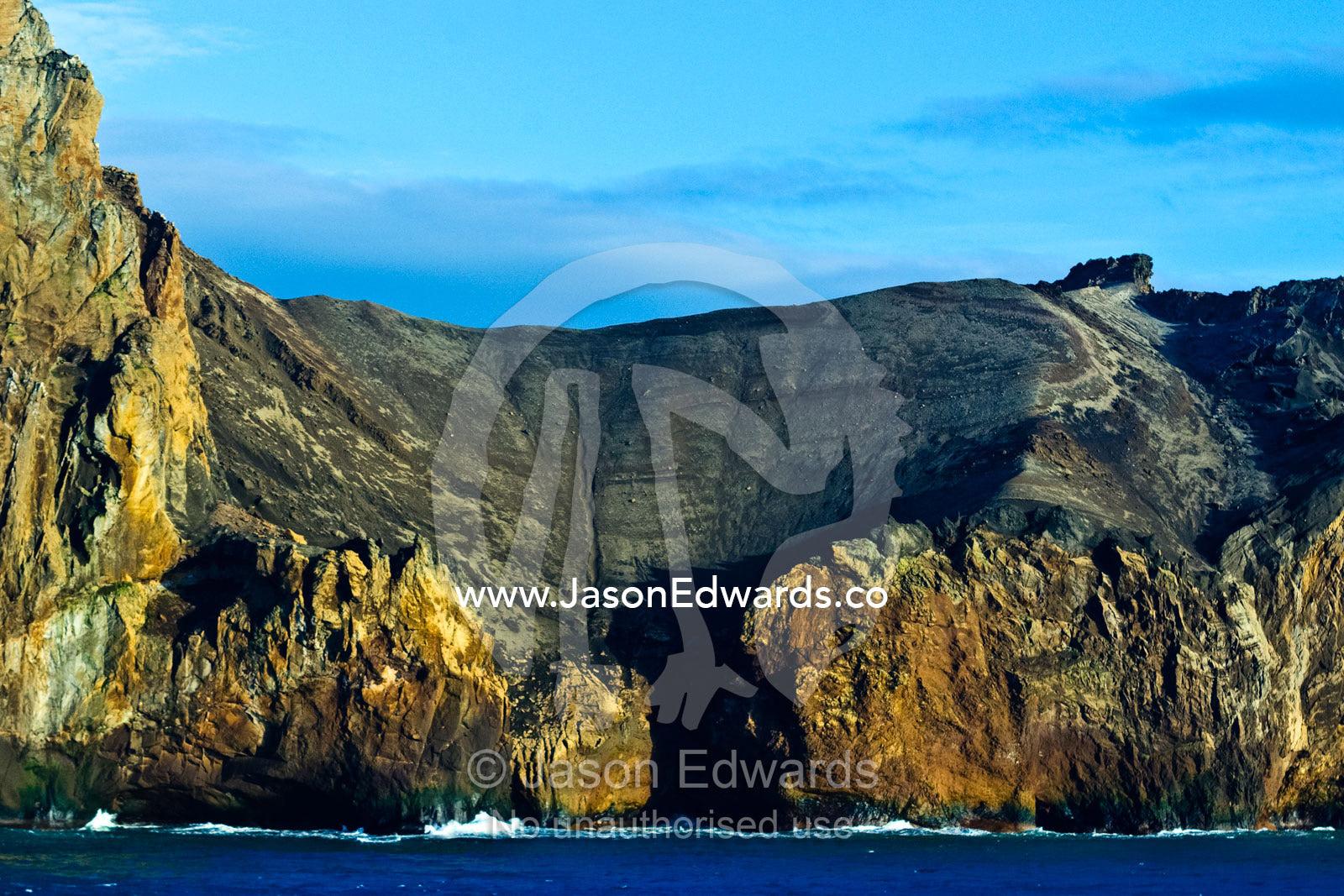 A rugged cliff face and escarpment surrounding a volcanic caldera. Bransfield Strait, Neptune's Bellows, Deception Island, South Shetland Islands, Antarctic Peninsula, Antarctica.