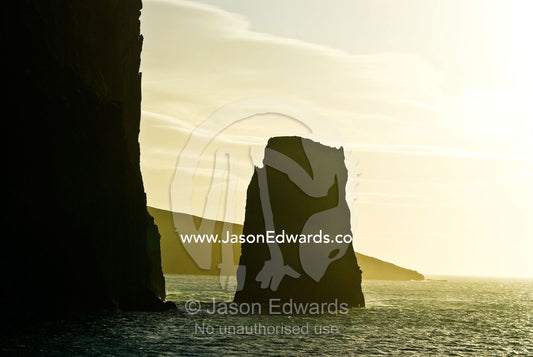 A rugged cliff face and pinnacle rock near a volcanic caldera. Bransfield Strait, Neptune's Bellows, Deception Island, South Shetland Islands, Antarctic Peninsula, Antarctica.