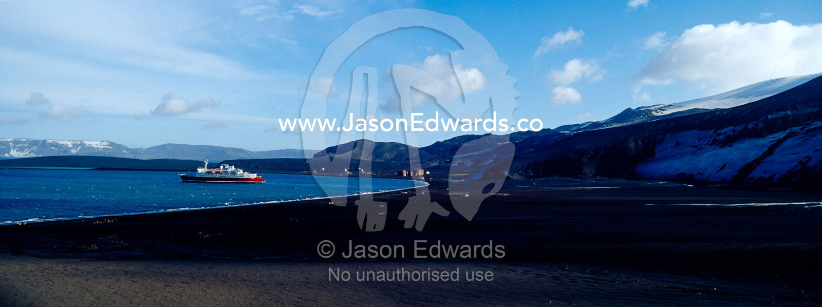 An ice strengthened ecotourism ship moored in volcano caldera bay. Hektor Whaling Station, Whalers Bay, Port Foster, Deception Island, South Shetland Islands, Antarctic Peninsula, Antarctica.