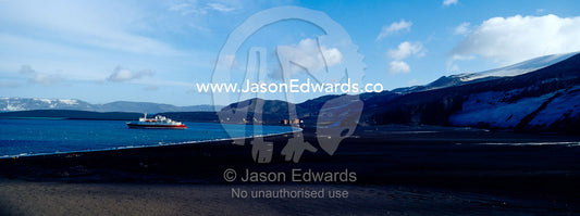 An ice strengthened ecotourism ship moored in volcano caldera bay. Hektor Whaling Station, Whalers Bay, Port Foster, Deception Island, South Shetland Islands, Antarctic Peninsula, Antarctica.