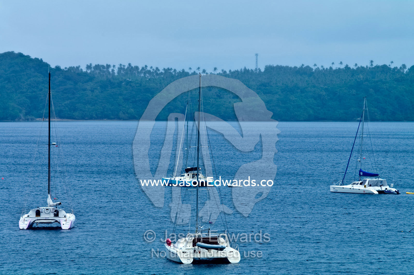 Catamaran yachts moored in the safe harbour of a tropical island. Port of Refuge, Neiafu, Vava'u Island Group, Pacific Ocean, Oceania, Kingdom of Tonga.