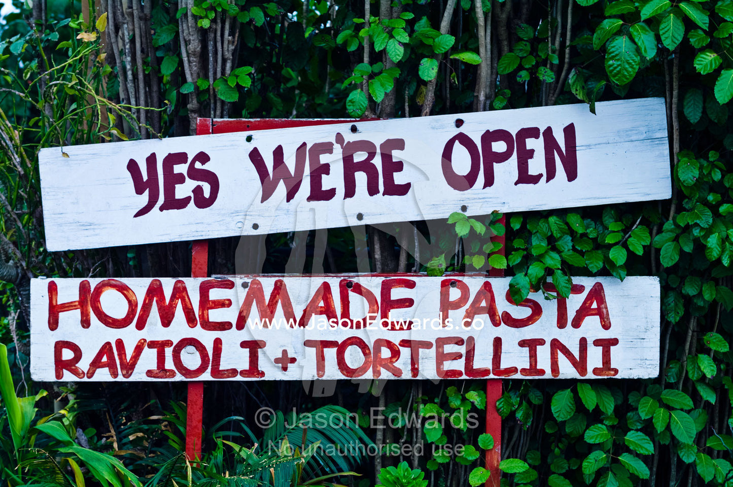 A bright red sign indicates an Italian pasta restaurant is open. Port of Refuge, Neiafu, Vava'u Island Group, Pacific Ocean, Oceania, Kingdom of Tonga.