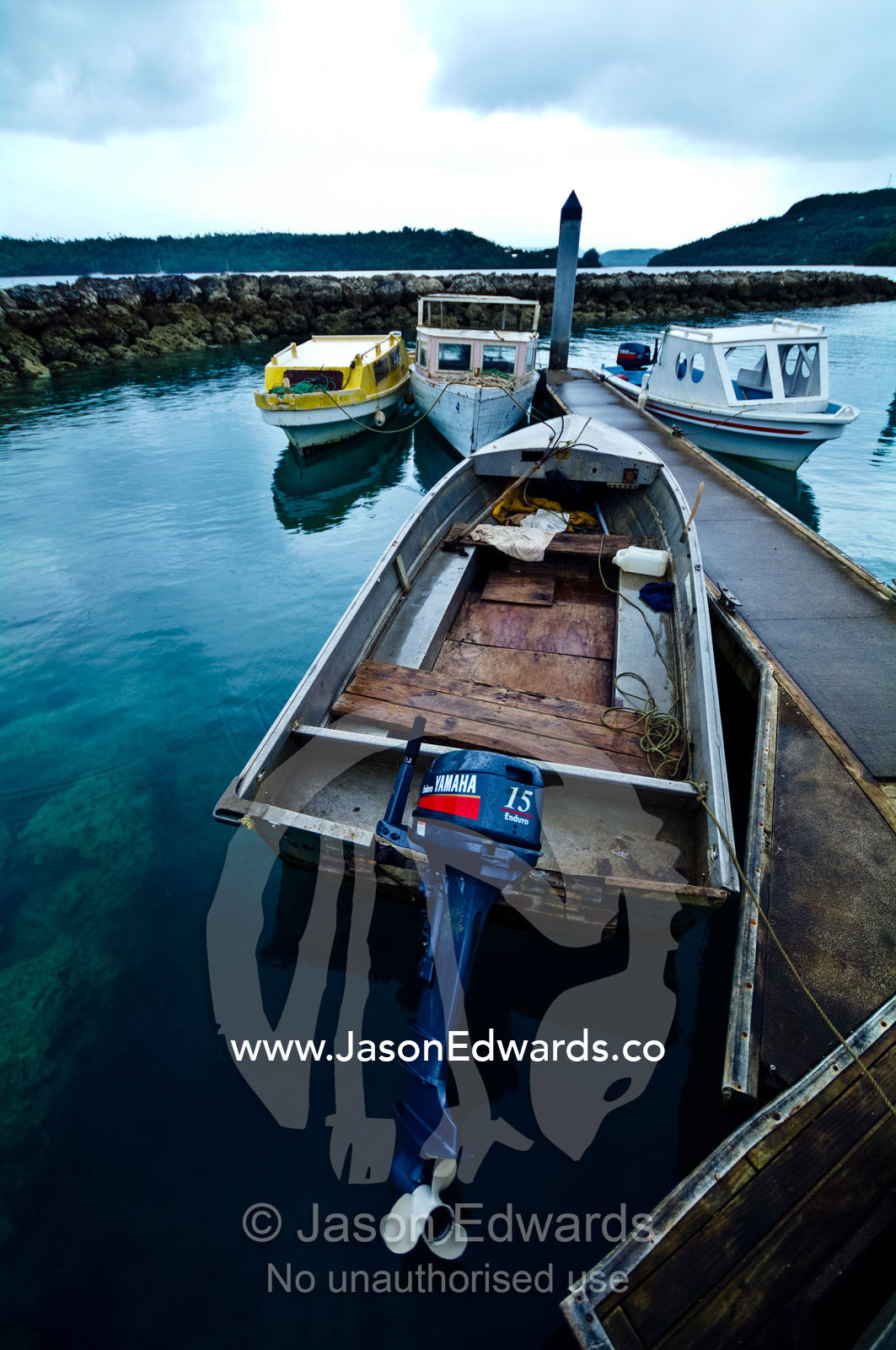 Weathered fishing boats and an aluminium punt moor in a safe harbour. Port of Refuge, Neiafu, Vava'u Island Group, Pacific Ocean, Oceania, Kingdom of Tonga.