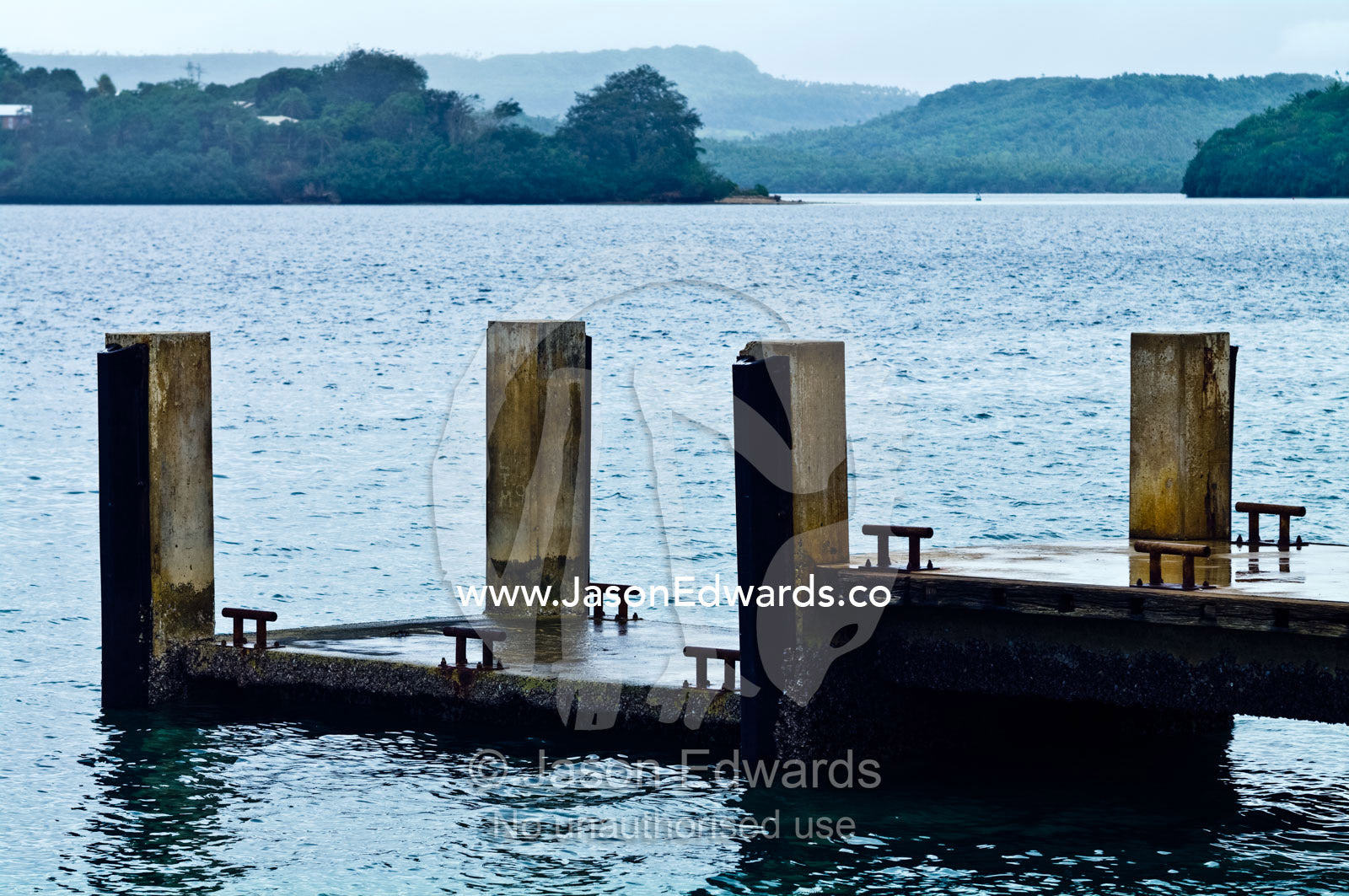 Concrete pillars support a mooring jetty on a tropical island. Port of Refuge, Neiafu, Vava'u Island Group, Pacific Ocean, Oceania, Kingdom of Tonga.