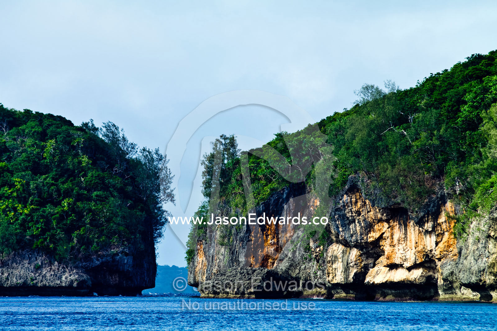 Lush forest above a channel eroded between two limestone islands. Vava'u Island Group, Pacific Ocean, Oceania, Kingdom of Tonga.