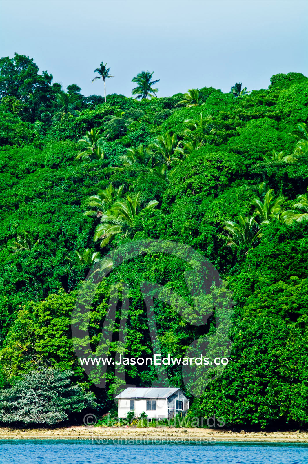 A small beach shack on the shore of a lush tropical rainforest island. Vava'u Island Group, Pacific Ocean, Oceania, Kingdom of Tonga.