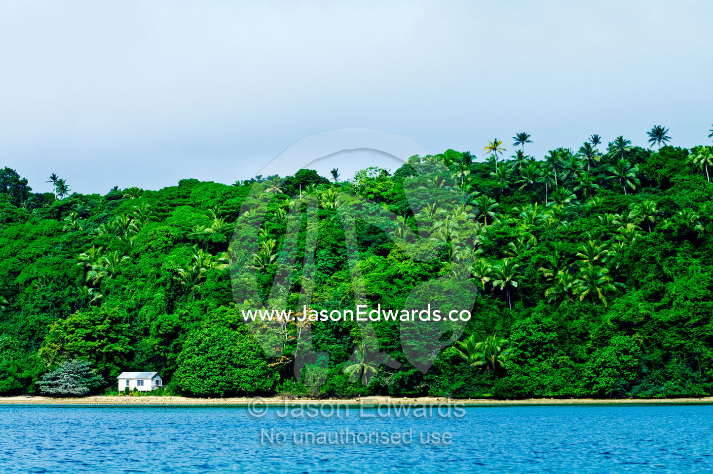A small beach shack on the shore of a lush tropical rainforest island. Vava'u Island Group, Pacific Ocean, Oceania, Kingdom of Tonga.