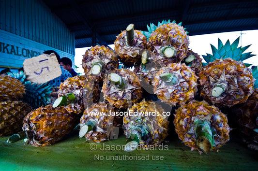 A stack of healthy ripe fresh pineapples for sale at a rural market. Utukalongalu Market, Port of Refuge, Neiafu, Vava'u Island Group, Pacific Ocean, Oceania, Kingdom of Tonga.