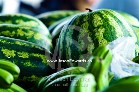 A stack of healthy ripe fresh watermelons for sale at a rural market. Utukalongalu Market, Port of Refuge, Neiafu, Vava'u Island Group, Pacific Ocean, Oceania, Kingdom of Tonga.
