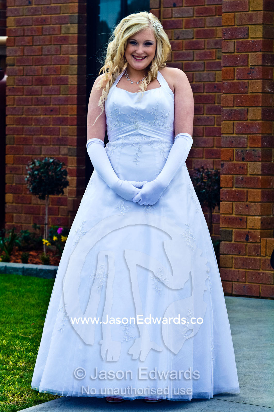 A teenage girl prepares to attend her debutante ball in a white dress. Melbourne, Victoria, Australia.