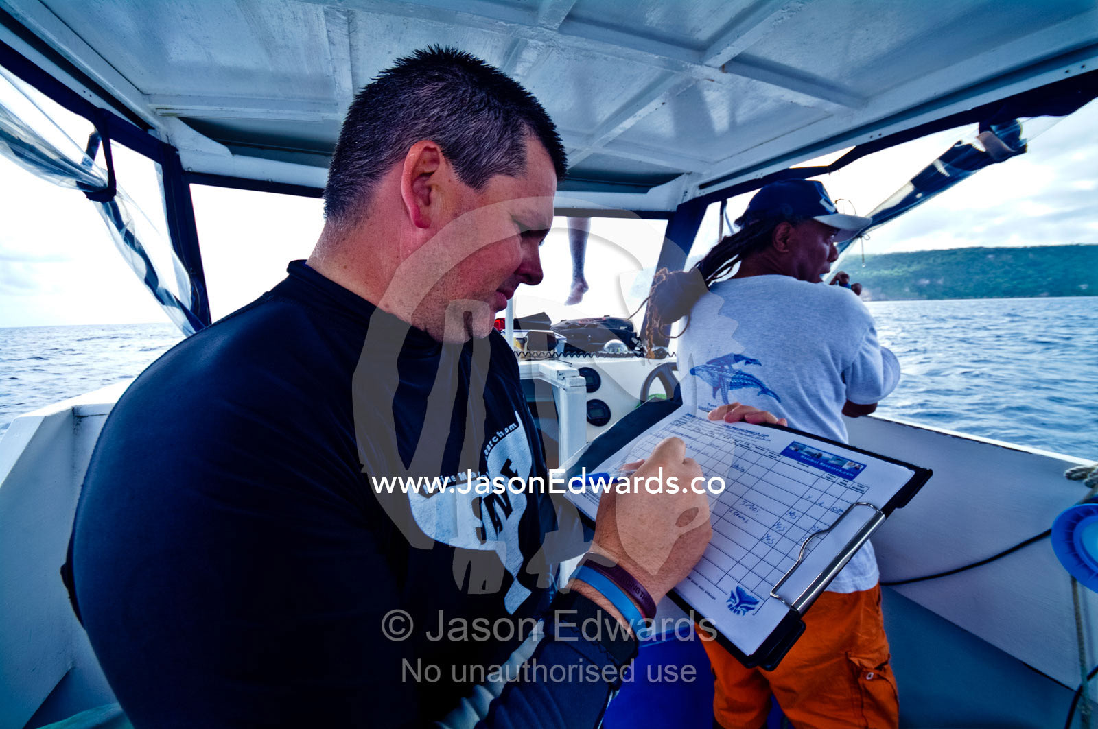 A Humpback Whale researcher records data from field observations. Vava'u Island Group, Pacific Ocean, Oceania, Kingdom of Tonga.