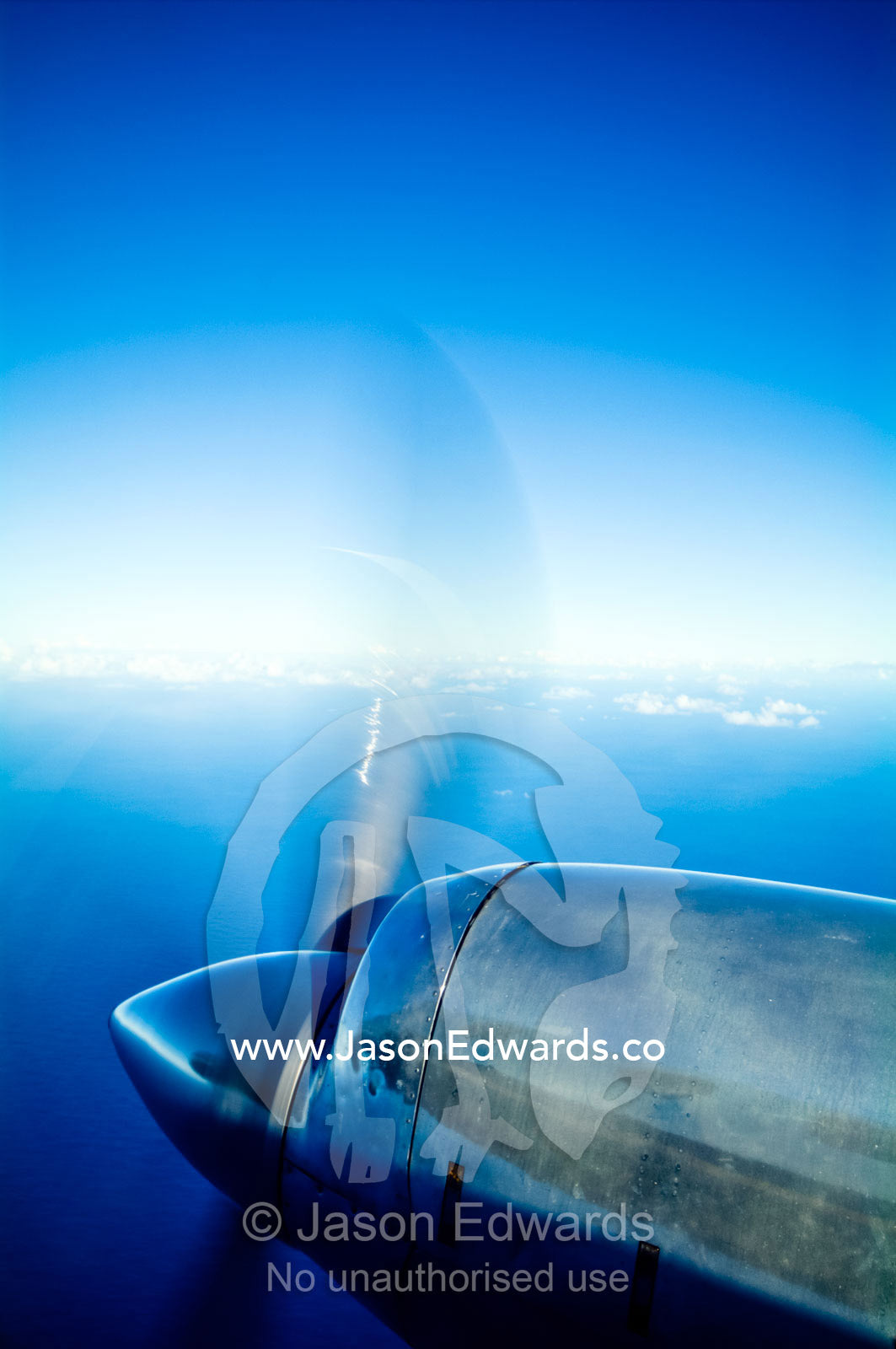 A chrome engine and propellor of a plane flying over tropical islands. Vava'u Island Group, Pacific Ocean, Oceania, Kingdom of Tonga.