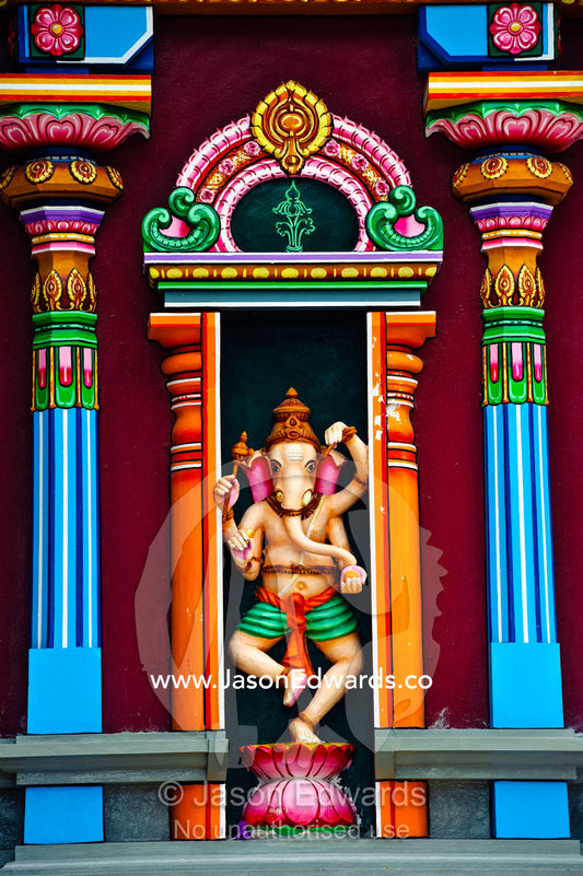 A colorful statue of Ganesh standing between pillars on a temple wall. Sri Siva Subramaniya Swami Temple, Nadi, Viti Levu Island, Pacific Ocean, Fiji Islands.