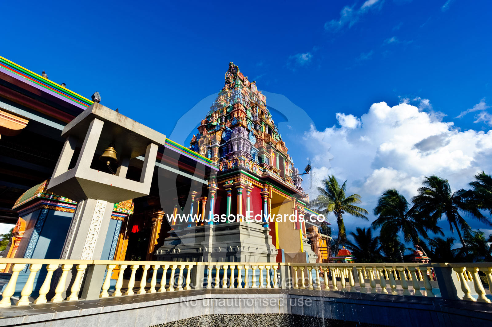 A brass bell and colorful statues adorn a Hindu temple. Sri Siva Subramaniya Swami Temple, Nadi, Pacific Ocean, Fiji Islands.