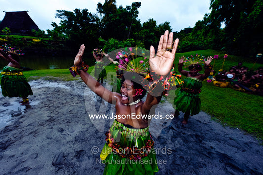 A woman throws her hands into the air during a Meke dance ceremony. Fiji Arts Village, Viti Levu, Pacific Ocean, Fiji Islands.