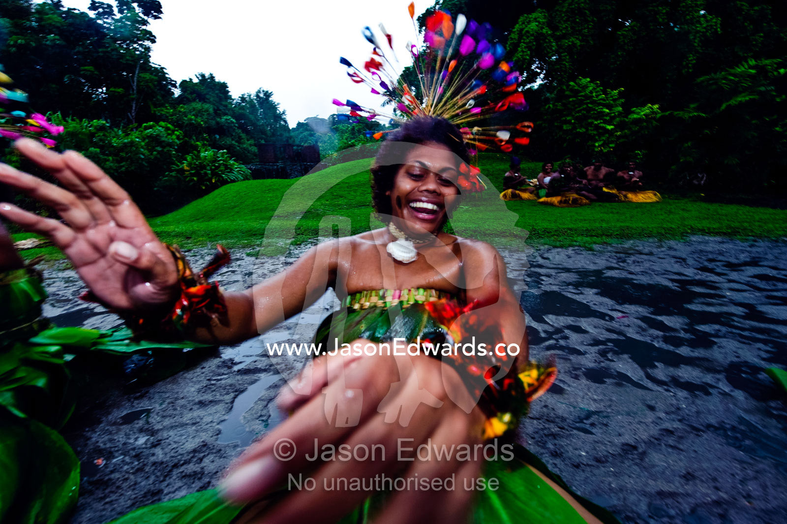 A woman throws her hands into the air during a Meke dance ceremony. Fiji Arts Village, Viti Levu, Pacific Ocean, Fiji Islands.