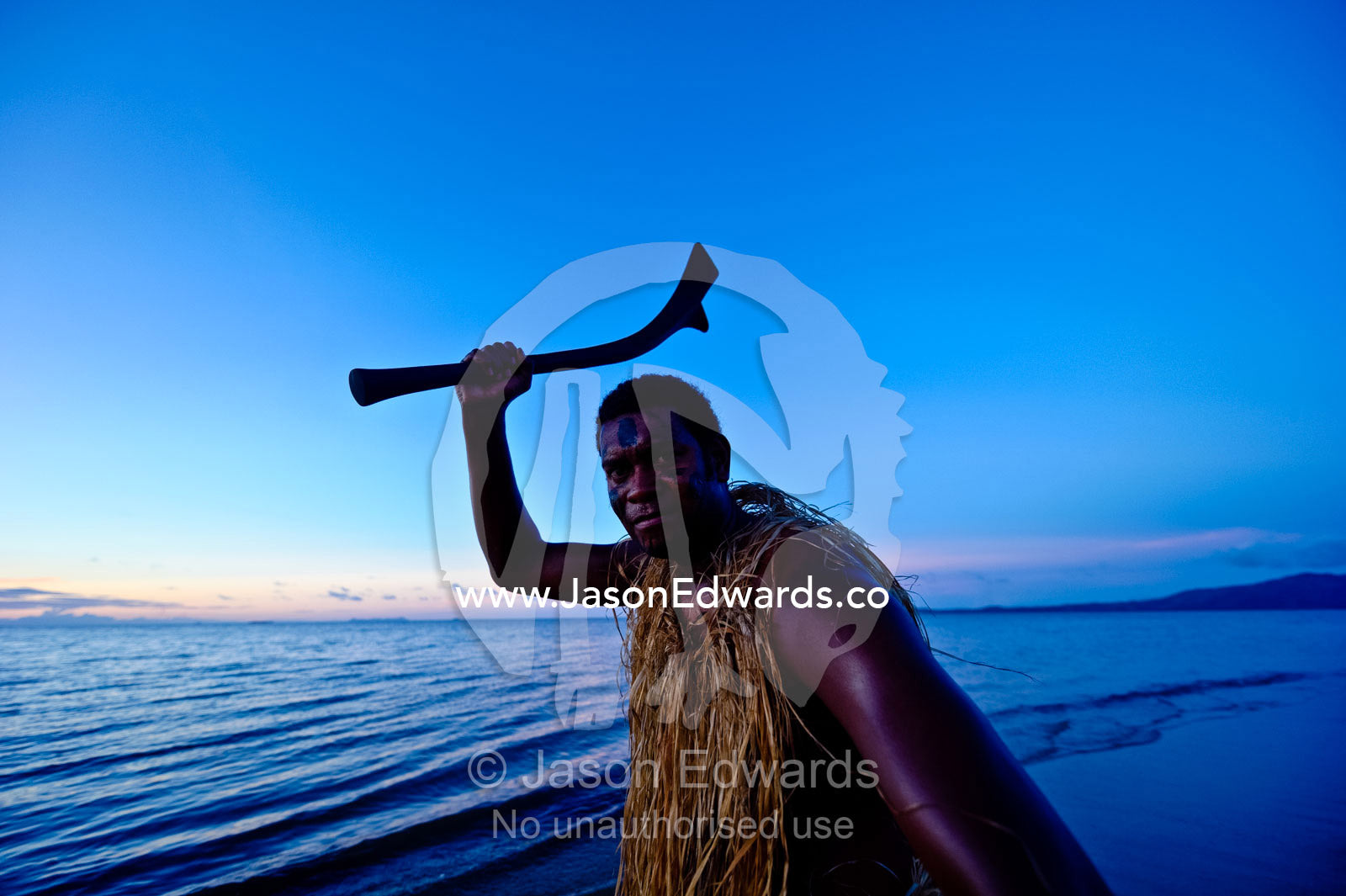 A warrior brandishes a traditional Thali club used in battle. Viti Levu, Pacific Ocean, Fiji Islands.