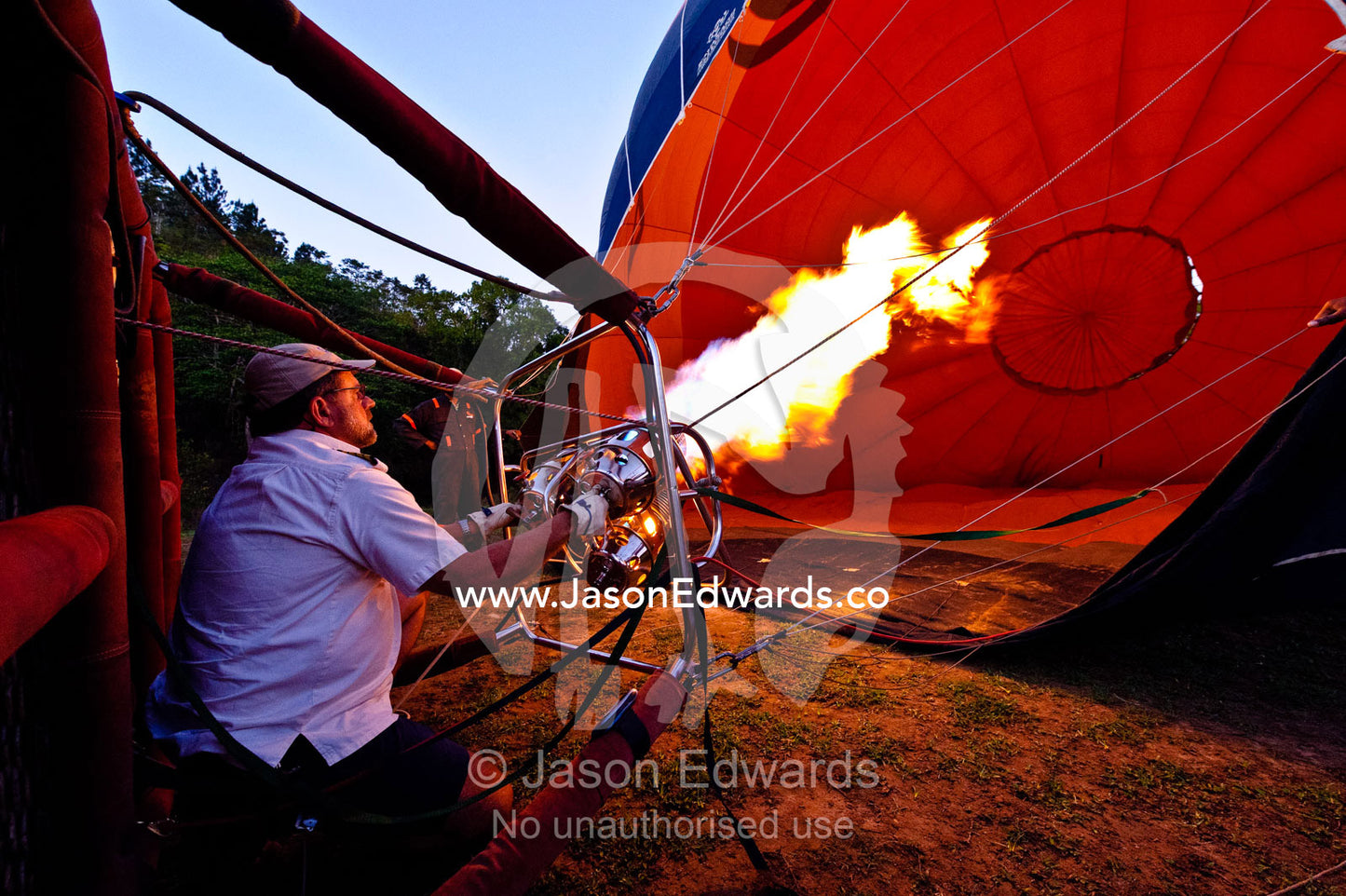 A pilot inflates a balloon canopy with hot air preparing for lift-off. Viti Levu, Pacific Ocean, Fiji Islands.