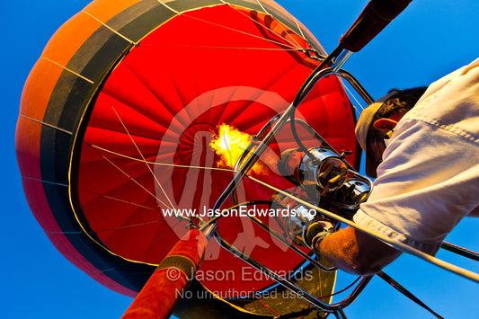 A pilot of a balloon controls altitude using hot air from burning gas. Viti Levu, Pacific Ocean, Fiji Islands.