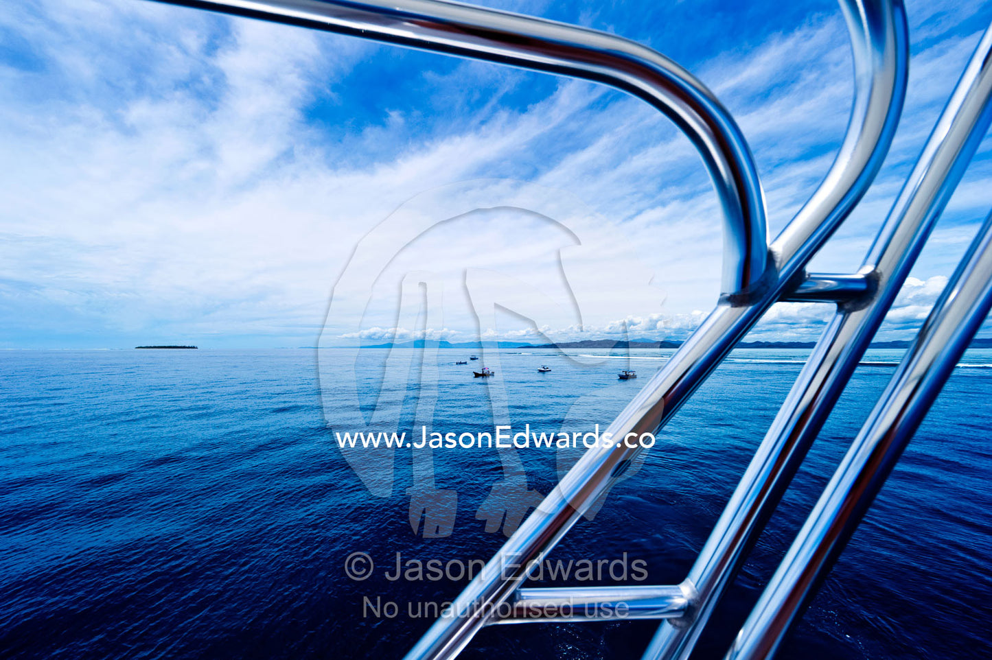 A stainless steel ladder and safety rail and a luxury speed boat. Cloudbreak Reef, Tavarua Island, Pacific Ocean, Fiji Islands.