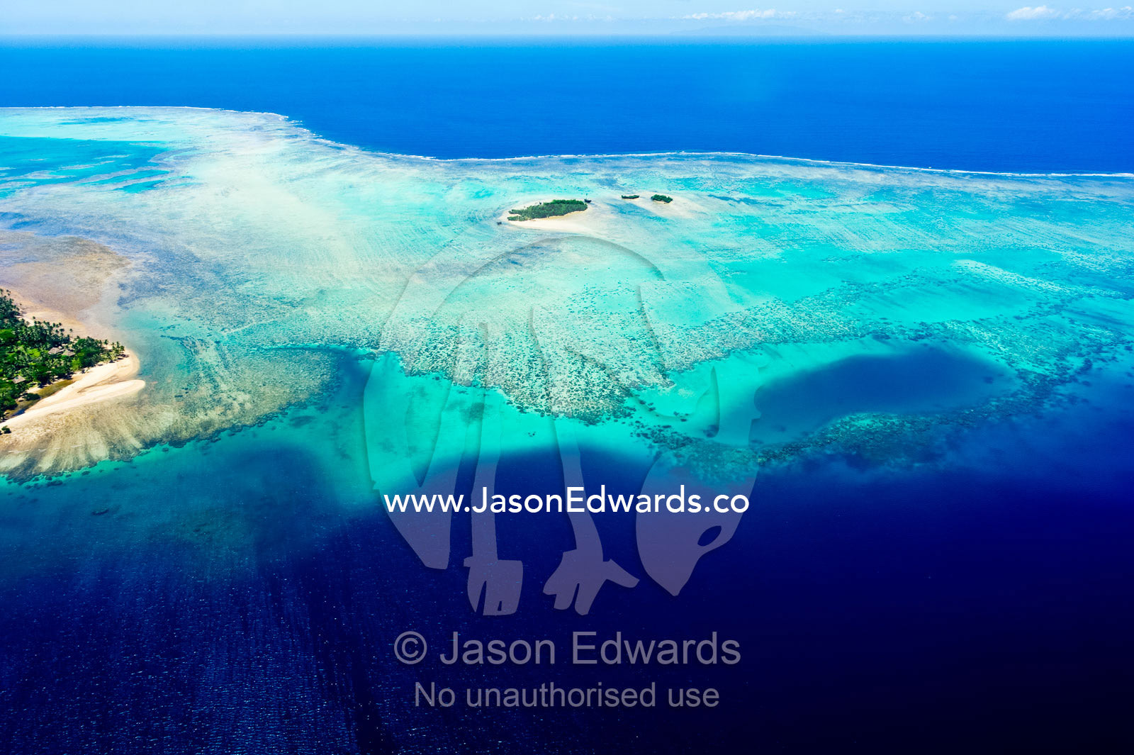 Coral reefs stretch out from the shoreline of a tropical island. Taveuni Island, Somosomo Strait, Pacific Ocean, Fiji Islands.