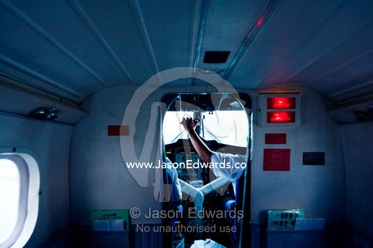 A pilot in the cockpit controls the planes acceleration in take-off. Taveuni Island, Pacific Ocean, Fiji Islands.