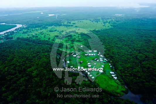 A small village and farmland surrounded by tropical rainforest. Viti Levu Island, Pacific Ocean, Fiji Islands.