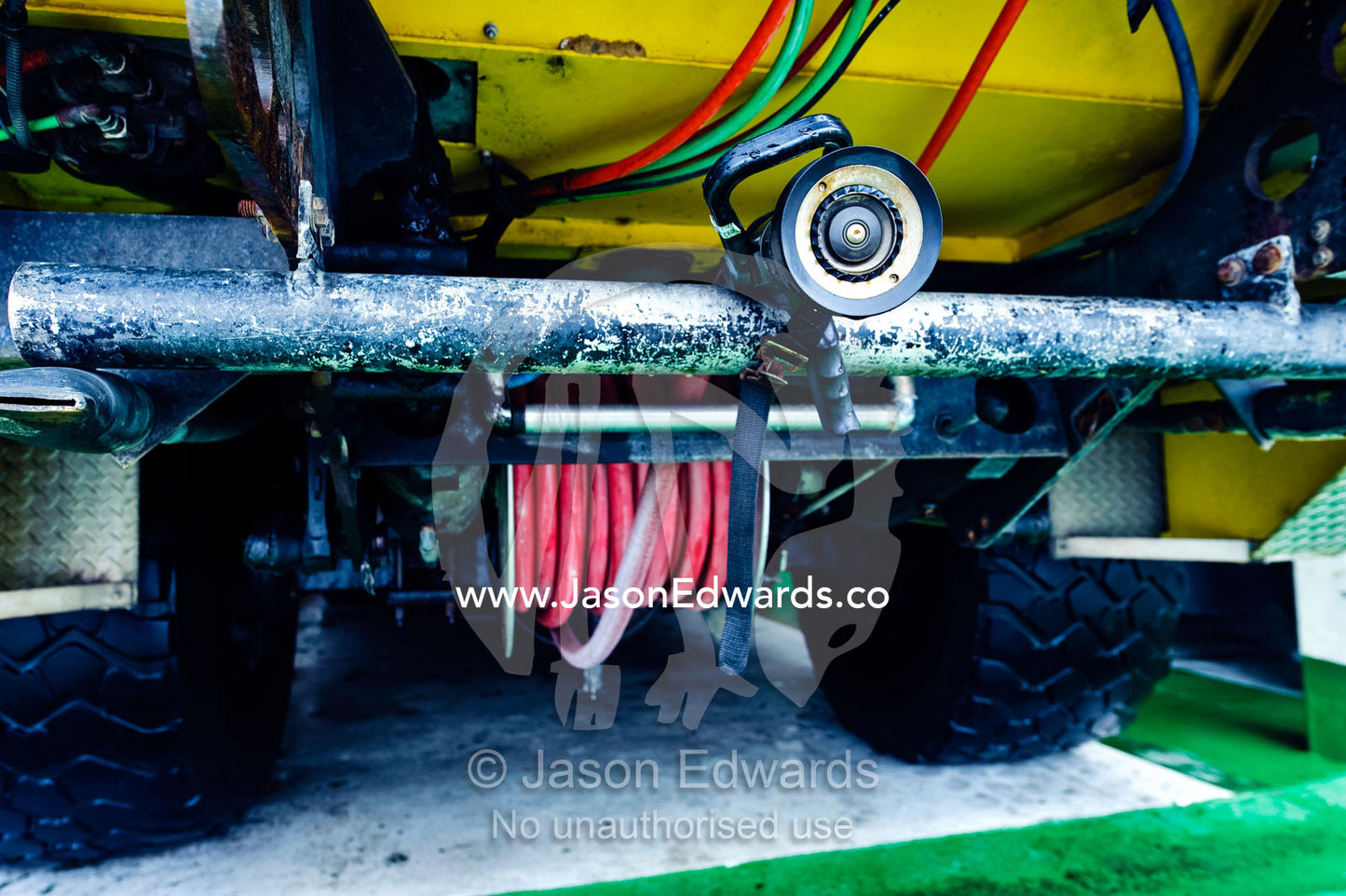 A fire hose nozzle protrudes from the front of an airport fire truck. Nausori Airport, Viti Levu Island, Pacific Ocean, Fiji Islands.